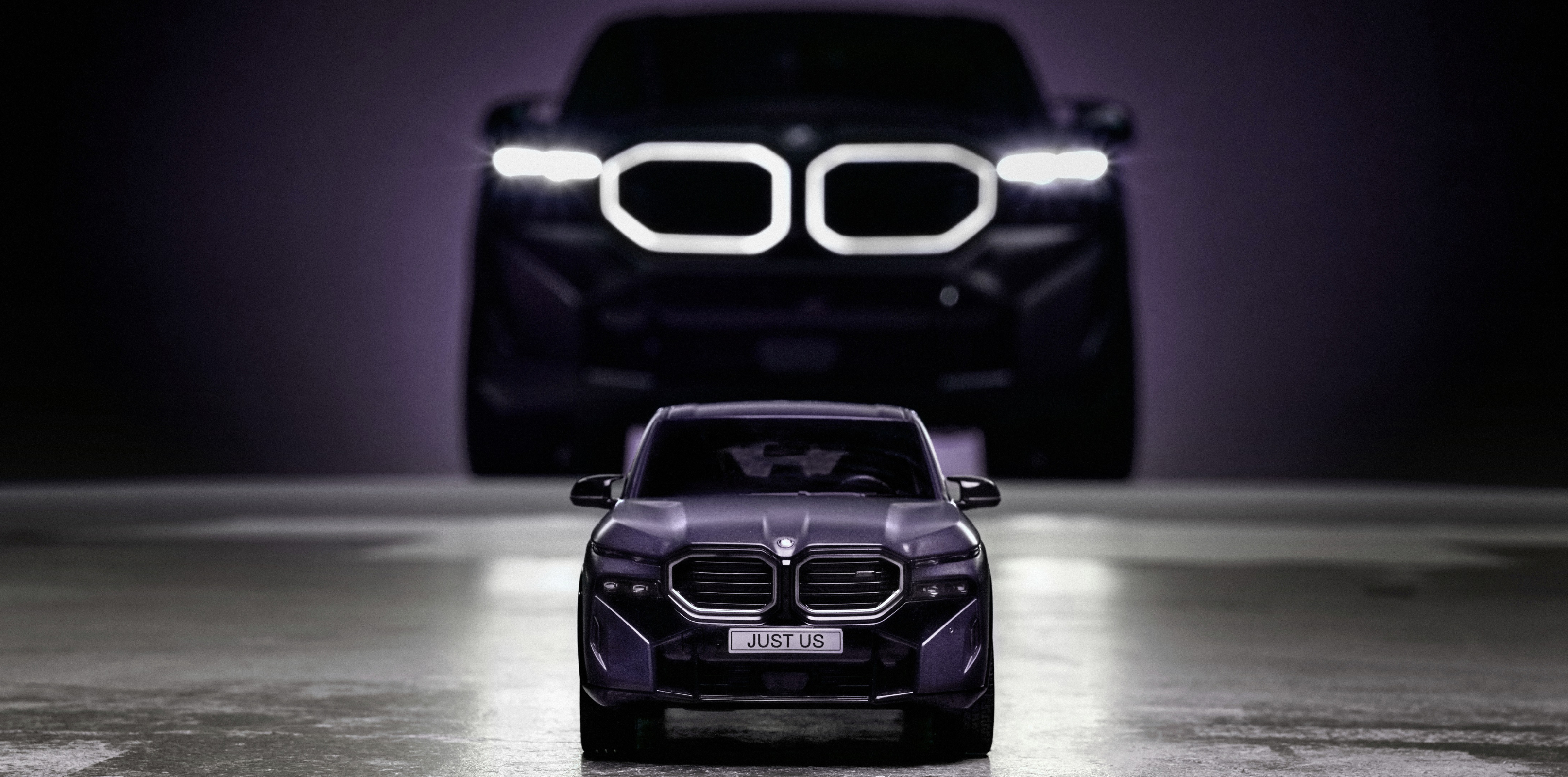 A BMW Miniature Car sits in front of the full-szie version of the same BMW model